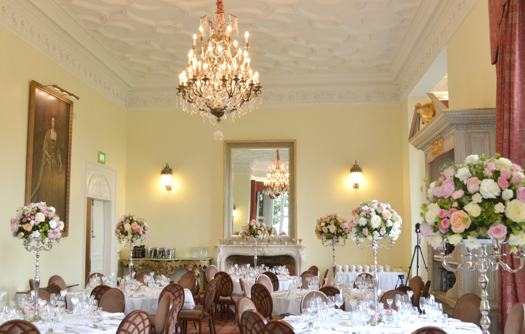 Cherie Kelly Fawsley Hall Wedding reception guests table candelabra flower arrangements tall and low centrepieces fireplace with candles