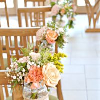 Rustic Orange and Peach Wedding Ceremony Aisle Flowers in Jam Jars at Rivervale Barn Hampshire Cherie Kelly